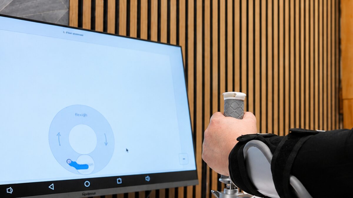A patient gripping the Smart Board handle during a baseline assessment, with the range-of-motion capture screen on the monitor.