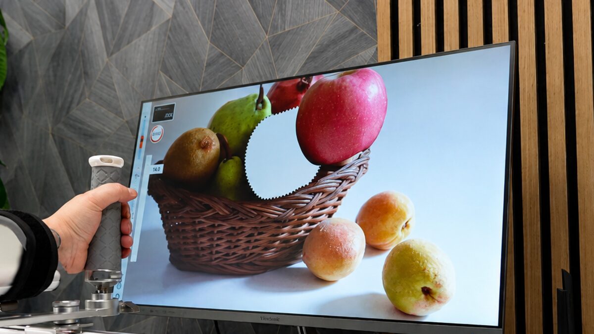 A patient moving the Smart Board handle to play a picture-reveal training game on screen.